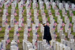 Pensiunan veteran Angkatan Darat AS Bill MacCully berziarah di Taman Makam Pahlawan Evergreen Washelli, di Seattle, pada Hari Veteran, Rabu, 11 November 2020. (Foto AP/Elaine Thompson)