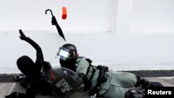 Riot police officer tries to subdue a protester during an anti-government demonstration in Hong Kong, China, November 10, 2019.