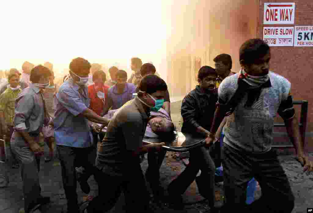 People help evacuate patients after a fire broke out at a hospital in Kolkata, India, Friday, Dec. 9. The fire swept through the multistory hospital in eastern India early Friday, trapping residents in the smoke-filled building. (AP/Bikas Das)