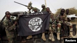 Tentara Nigeria memegang bendera Boko Haram bahwa mereka telah ditangkap di kota yang baru-baru ini direbut kembali dari Damasak, Nigeria, 18 Maret 2015 (Foto: dok)