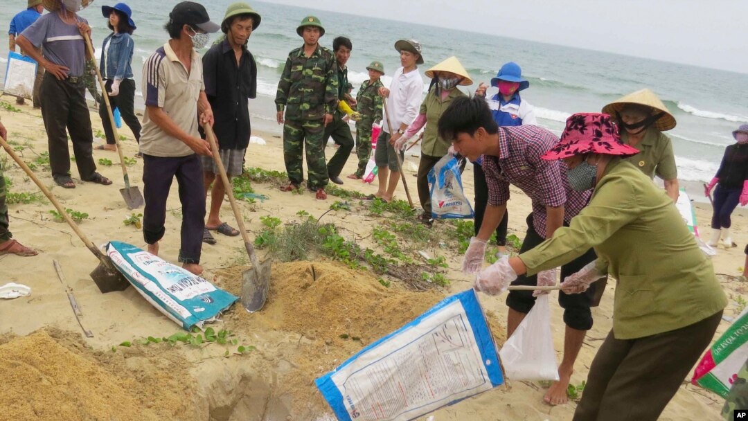 FILE- In this April 28, 2016, file photo, villagers bury dead fish on a beach in Quang Binh, Vietnam. Toxic waste discharged from a Taiwanese-owned Formosa Plastics Group steel complex unit in central Vietnam harmed the livelihoods of more than 200,000 people, including 41,000 fishermen, the Vietnamese government said on Friday in tallying the damage from what it has called the country’s worst environmental disaster according to local media. The company has pledged to pay $500 million in compensation.