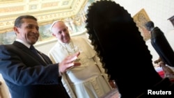 FILE - Pope Francis exchanges gifts with Peru's President Ollanta Humala during a private audience at the Vatican, Nov. 14, 2014.