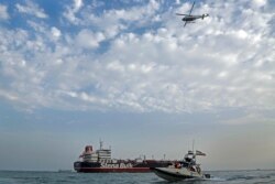 FILE - A speedboat and a helicopter of the Iran's Revolutionary Guard move around a British-flagged oil tanker Stena Impero, which was seized by the Guard, in the Iranian port of Bandar Abbas, July 21, 2019.