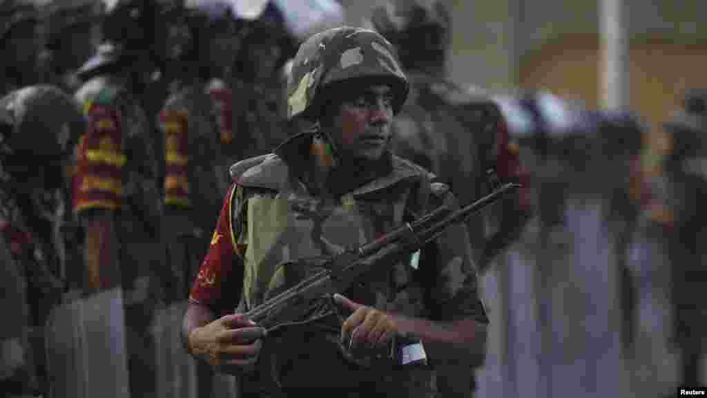 Army soldiers take their positions in front of Morsi opponents, near the Republican Guard headquarters in Cairo, July 3, 2013. 