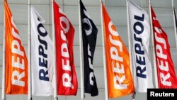 FILE - Repsol flags are seen at a conference hall during the company's annual shareholders meeting in Madrid, Spain, May 19, 2017. 