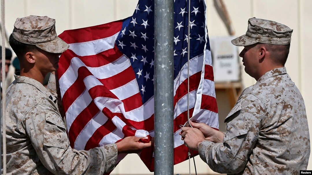 FILE - U.S. officials say they'll discard plans to draw down troop strength to 5,500 by year's end in Afghanistan. Here, U.S. Marines lower their flag during a handover ceremony, as the last U.S. Marines unit and British combat troops end their Afghan operations in Helmand, Oct. 26, 2014. 