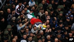 Palestinians carry the body of policeman Tariq Badwan during his funeral in the West Bank village of Azoun near Qalqilya, Feb. 7, 2020.