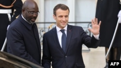 Le président libérien George Weah et le président français Emmanuel Macron, quittent l'Elysée après un déjeuner à Paris, le 21 février 2018.