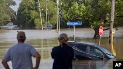 Warga setempat mengamati banjir yang menggenangi jalan Old Jefferson Highway di Bayou Manchac, Prairieville, Louisiana, 16 Agustus 2018 (AP Photo/Max Becherer).