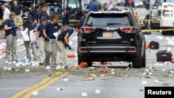 Para penyelidik FBI mengumpulkan barang bukti di lokasi ledakan di kawasan Chelsea, Manhattan, New York hari Minggu (18/9).