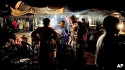 Women purchase grilled chicken from a street vendor in a market in Juba, South Sudan. Outdoor food vendors say inspections by health officials and a drop in clientele during the cholera outbreak are forcing them to shut down. 