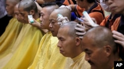 Pro-democracy activists get their heads shaved to protest against China's legislature, during a ceremony in Hong Kong, Sept. 9, 2014.