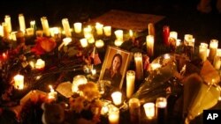 A picture of U.S. Representative Gabrielle Giffords (D-AZ) is surrounded by candles during a vigil outside the Tucson University Medical Center in Tucson, Arizona, 08 Jan 2011.