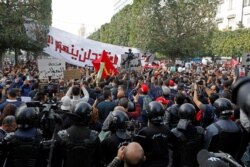 Demonstrators attend a protest to mark the anniversary of a prominent activist's death and against allegations of police abuse, in Tunis, Tunisia, Feb. 6, 2021.