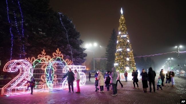 La gente camina en una plaza decorada para las festividades de Navidad y Año Nuevo en Donetsk, en la región de Donetsk controlada por Rusia, en el este de Ucrania, el 31 de diciembre de 2024.