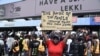 A demonstrator holds a placard to protest against abuses by the Special Anti-Robbery Squad (SARS) at the Lekki toll plaza in Lagos, Nigeria, Oct. 12, 2020.