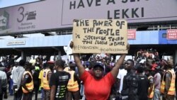 A demonstrator holds a placard to protest against abuses by the Special Anti-Robbery Squad (SARS) at the Lekki toll Plaza in Lagos, Nigeria, Oct. 12, 2020.