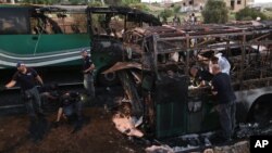 FILE - Israeli police officers work at the scene of a bus explosion in Jerusalem, April 18, 2016. One of the 21 people injured in the blast died Wednesday.