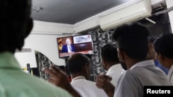Supporters of President Ranil Wickremesinghe watch the TV while he addresses the nation, after the International Monetary Fund's executive board approved a $3 billion loan, in outskirts of Colombo, Sri Lanka March 21, 2023.
