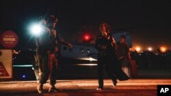 Marinir mengawal seorang pegawai Departemen Luar Negeri yang akan dievakuasi, di Bandara Internasional Hamid Karzai, di Kabul, Afghanistan, 15 Agustus 2021. (Foto: AP)