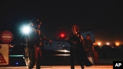 FILE - A Marine escorts a U.S. State Department employee to be processed for evacuation, at Hamid Karzai International Airport, in Kabul, Afghanistan, Aug. 15, 2021. The U.N. also evacuated about 100 staff, moving them to Kazakhstan on Aug. 18, 2021.