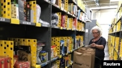 Un empleado recolecta artículos pedidos por clientes de Amazon.com en un almacén en San Francisco, California, el 20 de diciembre de 2017.