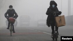 People ride amid the smog in Beijing, China, Feb. 14, 2017. 