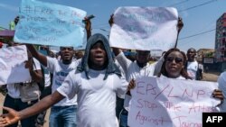 Journalists hold up signs protesting what they claim has been a pattern of using excessive force against them by the police and members of the government's security forces in Monrovia, Liberia, March 12, 2020.