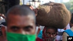 12일 인도 뭄바이의 한 시장에서 여성이 채소를 머리에 이고 가고 있다. 