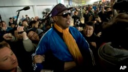 ນາຍ Dennis Rodman ອະດີດນັກກີລາບານບ້ວງ ອາເມຣິກັນ ເວລາເດີນທາງໄປຮອດ ສະໜາມບິນສາກົນຂອງ ກຸງປັກກິງ ຈາກກຸງພຽງຢາງ, ວັນທີ 13 ມັງກອນ 2014.