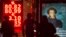 People walk past a currency exchange display board showing the value of the Russian ruble against the U.S. dollar and the euro, in Moscow, Russia, Jan. 20, 2016.