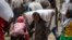 FILE - An Ethiopian man carries a sack of wheat on his shoulders to be distributed by the Relief Society of Tigray in the town of Agula, in the Tigray region of northern Ethiopia, on May 8, 2021