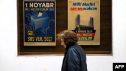 A woman walks past electoral posters in Baku on October 31, 2015, a day ahead of the parliamentary election in Azerbaijan.