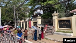 People wait at Insein prison in hopes of the release of their families members who were arrested due to the anti-coup protests, in Yangon