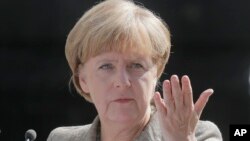 FILE - German chancellor Angela Merkel makes a statement to the press in Kyiv, Ukraine, Aug. 23, 2014. 