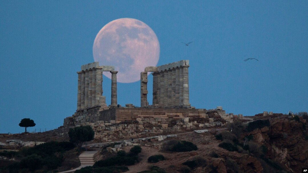 Burung camar terlihat terbang di angkasa, saat bulan purnama menyinari bumi dari balik marmer kuil kuno Poseidon di Cape Sounion, sebelah tenggara Athena, 20 Juni 2016 (Foto: dok).
