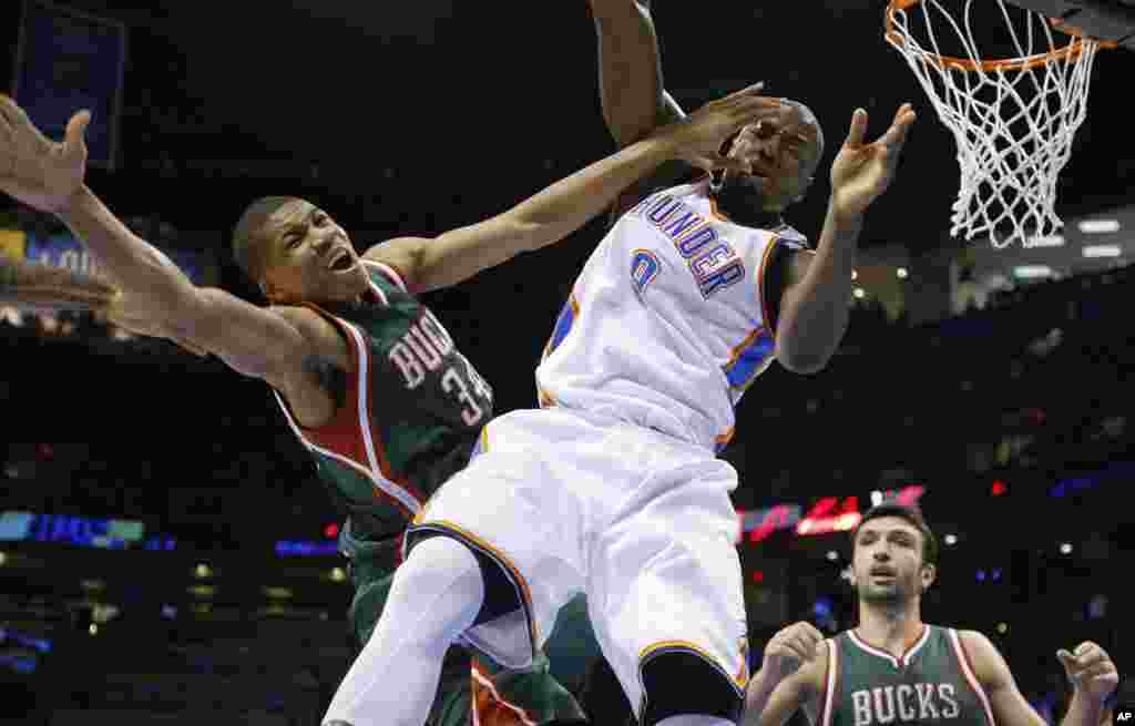Le meneur Yánnis Antetokoúnmpo de Milwaukee (34) et l&rsquo;ailier d&rsquo;Oklahoma City Serge Ibaka (9) entrent en collision lors du deuxième quart temps du match de NBA. Oklahoma City, mardi 9 décembre 2014. &nbsp;