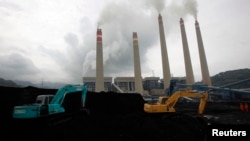 Ekskavator menimbun batu bara di tempat penyimpanan di sebuah pembangkit di Suralaya, Banten, 20 Januari 2010. (Foto: Ilustrasi/Reuters)