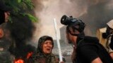 A member of the Egyptian security forces speaks to a woman holding a stick as they clear a sit-in by supporters of ousted Islamist President Mohammed Morsi, at the smaller of the two camps, near the Cairo University campus in Giza, Cairo, Egypt, August 14, 2014.