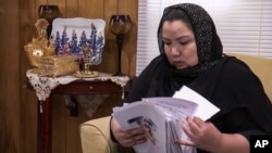 Zumret Dawut, a Uighur from China's Xinjiang region, who holds documents she brought with her, at her new home in Woodbridge, Va., June 15, 2020, says she was forcibly sterilized for having a third child.