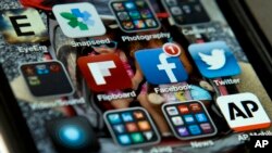 FILE - An iPhone with Twitter, Facebook and other apps, May 21, 2013. Facebook said the Department of Homeland Security would be violating company rules if agents create fake profiles to monitor the social media of foreigners seeking U.S. entry.