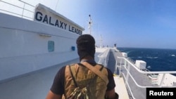 FILE -- A Houthi fighter stands on the Galaxy Leader cargo ship in the Red Sea in this photo released November 20, 2023.