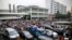 FILE - Workers protest during a strike as police stand guard at the factory area of Yue Yuen Industrial, in Dongguan, Guangdong province, April 18, 2014.