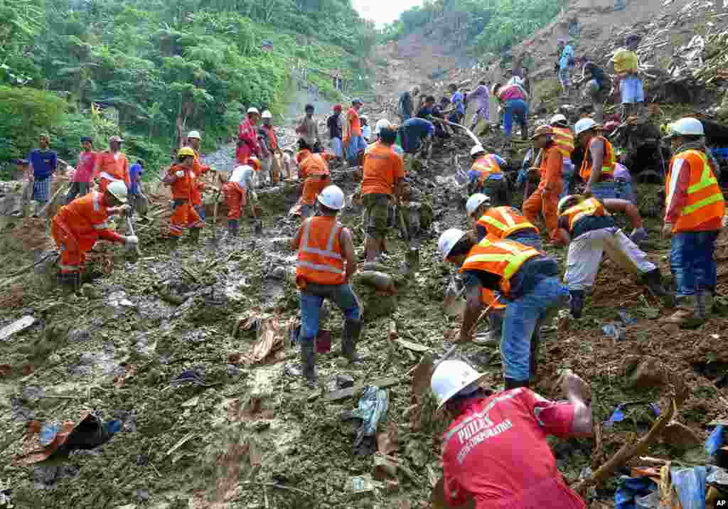 Rescuers use shovels to dig at the site of a landslide during a search and rescue operation. (Reuters)