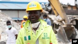 FILE- Ibrahim Farinloye, spokesman for the Nigerian Emergency Management Agency, speaks on the rubble of a collapsed building belonging to the Synagogue Church of All Nations in Lagos, Nigeria, Sept. 17, 2014.