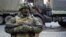 FILE - A pro-Russia rebel stands guard during preparations for a prisoner exchange in Donetsk, eastern Ukraine, Oct. 29, 2015.