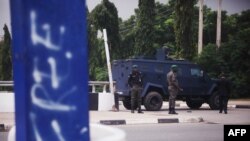 FILE - Policemen guard the road to the Aso Villa, official residence of the President of Nigeria, during clashes between members of the Shi'ite Islamic Movement of Nigeria and the police, July 22, 2019. 