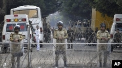 Egyptian soldiers stand behind a barbed wire fence while guarding the Cabinet building near Tahrir Square in Cairo, Egypt, Saturday, Nov. 26, 2011.