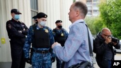 El abogado ruso Ivan Pavlov pasa junto a los agentes de policía para asistir a una sesión del tribunal después de hablar con los medios de comunicación en el Tribunal de Moscú en Moscú, Rusia, el 9 de junio de 2021.