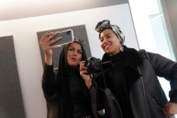 Amani Al-Khatahtbeh, left, films a video with Maryam Saad after recording a podcast pilot at Spotify's headquarters in New York, Dec. 19, 2019. Al-Khatahtbeh started the website as a way to defy Muslim stereotypes after 9/11.